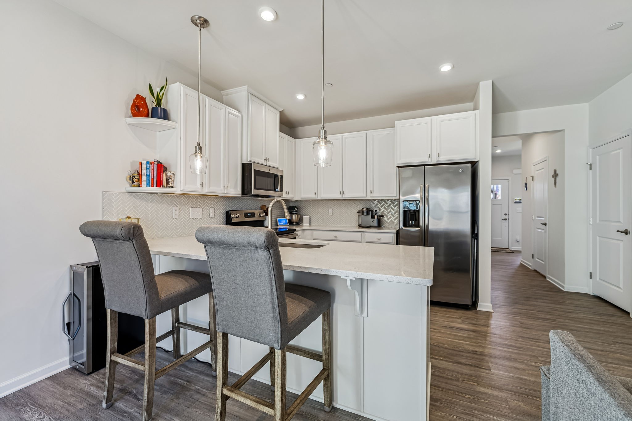 156 Keelon Gap Road Spring Hill, TN 37174 - Photo 13 of 39 a kitchen with stainless steel appliances granite countertop a sink a stove a refrigerator and a dining table with wooden floor