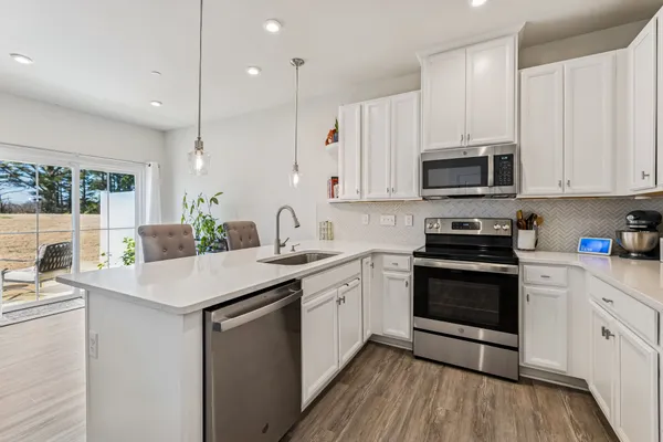 a kitchen with stainless steel appliances granite countertop a sink a stove a microwave and cabinets