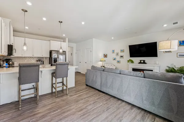 a large white kitchen with cabinets and chairs
