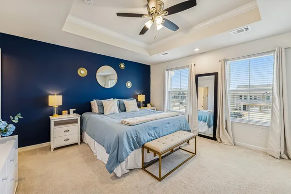 a spacious bedroom with a bed and a chandelier