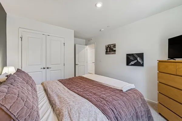 a bedroom with a bed and flat screen tv