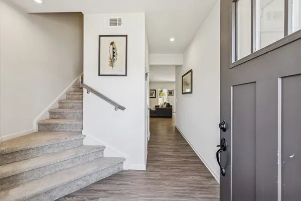 a view of staircase with lots of frames and paintings on wall
