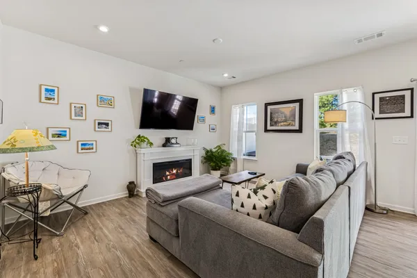 a living room with furniture a flat screen tv and a fireplace