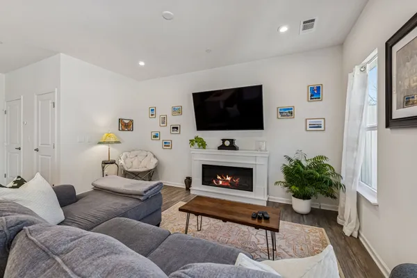 a living room with furniture a flat screen tv and a fireplace