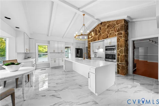 a kitchen with stainless steel appliances kitchen island granite countertop a refrigerator and microwave