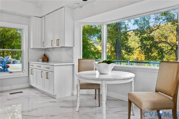 a kitchen with a stove a table and chairs in it
