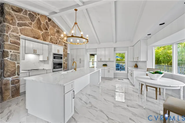 a large white kitchen with a large window and stainless steel appliances