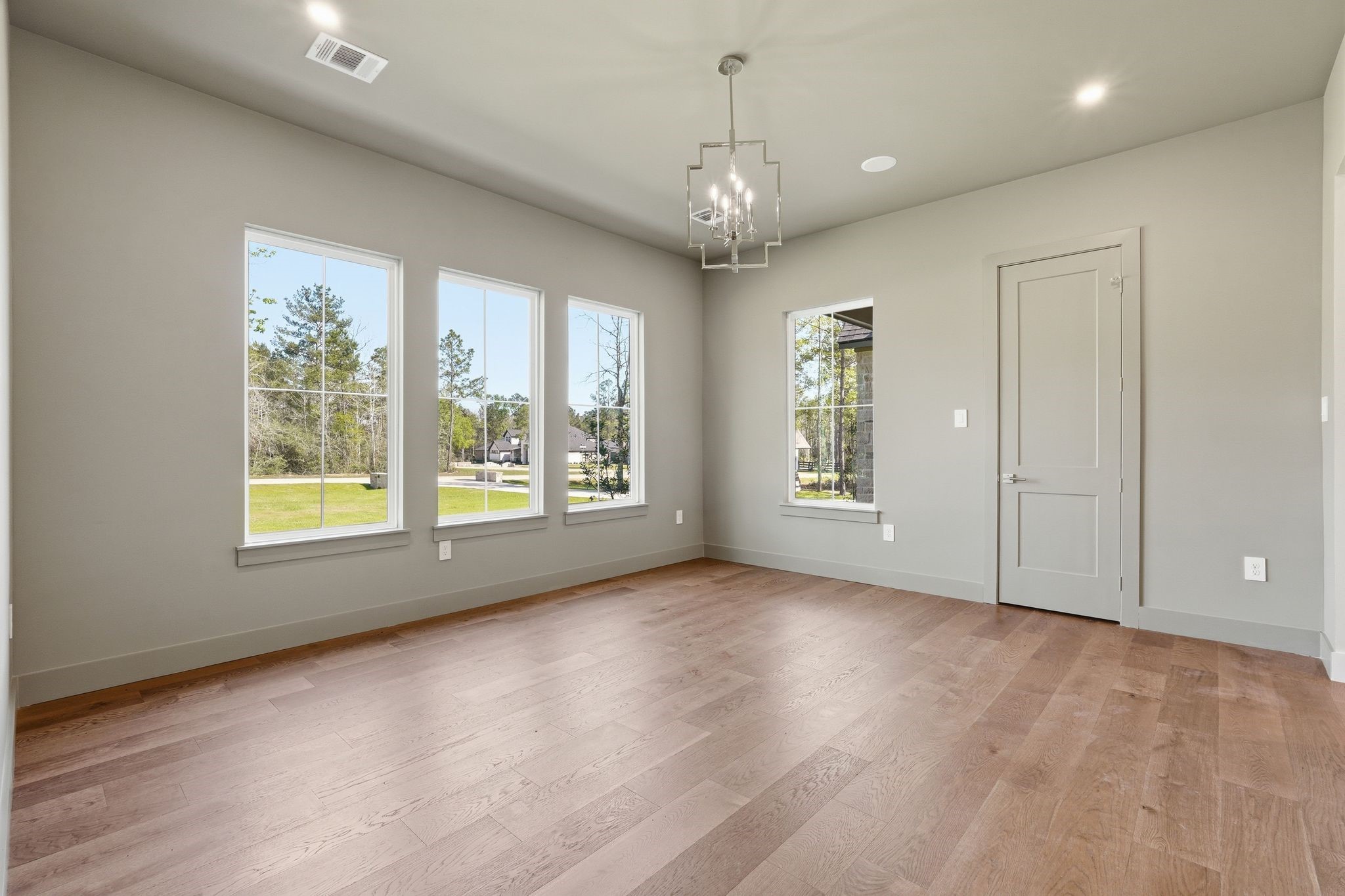 7248 Red Oak Grove Road Montgomery, TX 77316 - Photo 5 of 50 an empty room with wooden floor chandelier and windows
