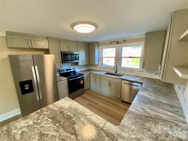 a kitchen with a refrigerator sink and wooden floor