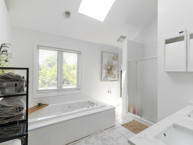 918 Meadow Road Northbrook, IL 60062 - Photo 18 of 38 a bathroom with a tub a window and a shower