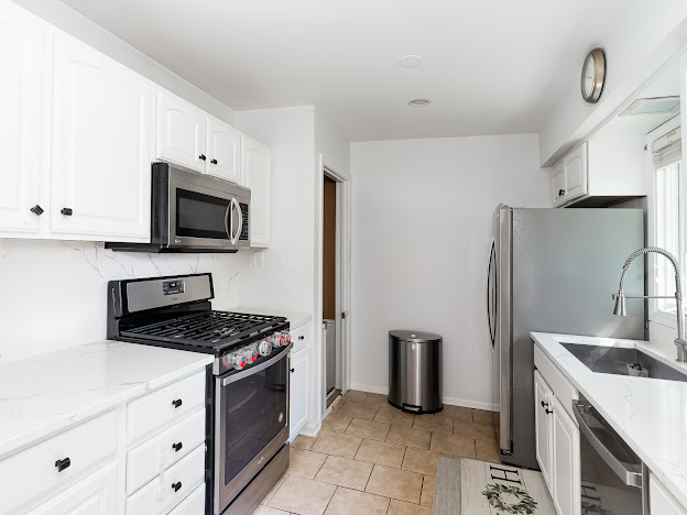 918 Meadow Road Northbrook, IL 60062 - Photo 8 of 38 a kitchen with a refrigerator stove and white cabinets