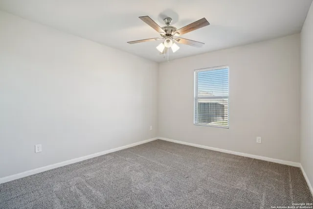 an empty room with a ceiling fan and a fan