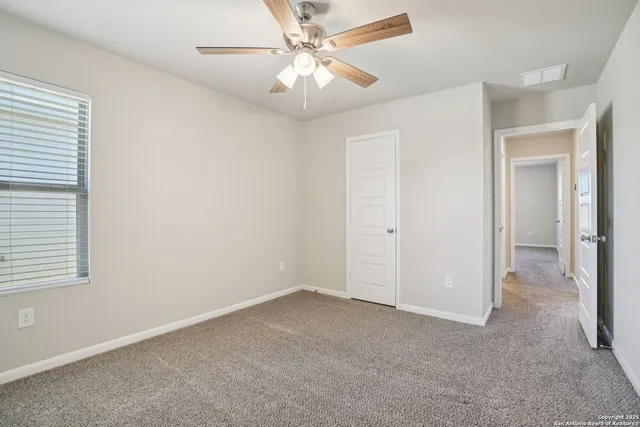 an empty room with a ceiling fan and a fan