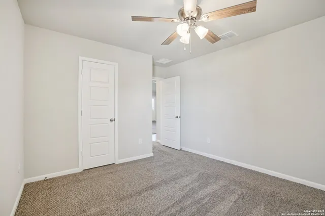 an empty room with a window and a fan