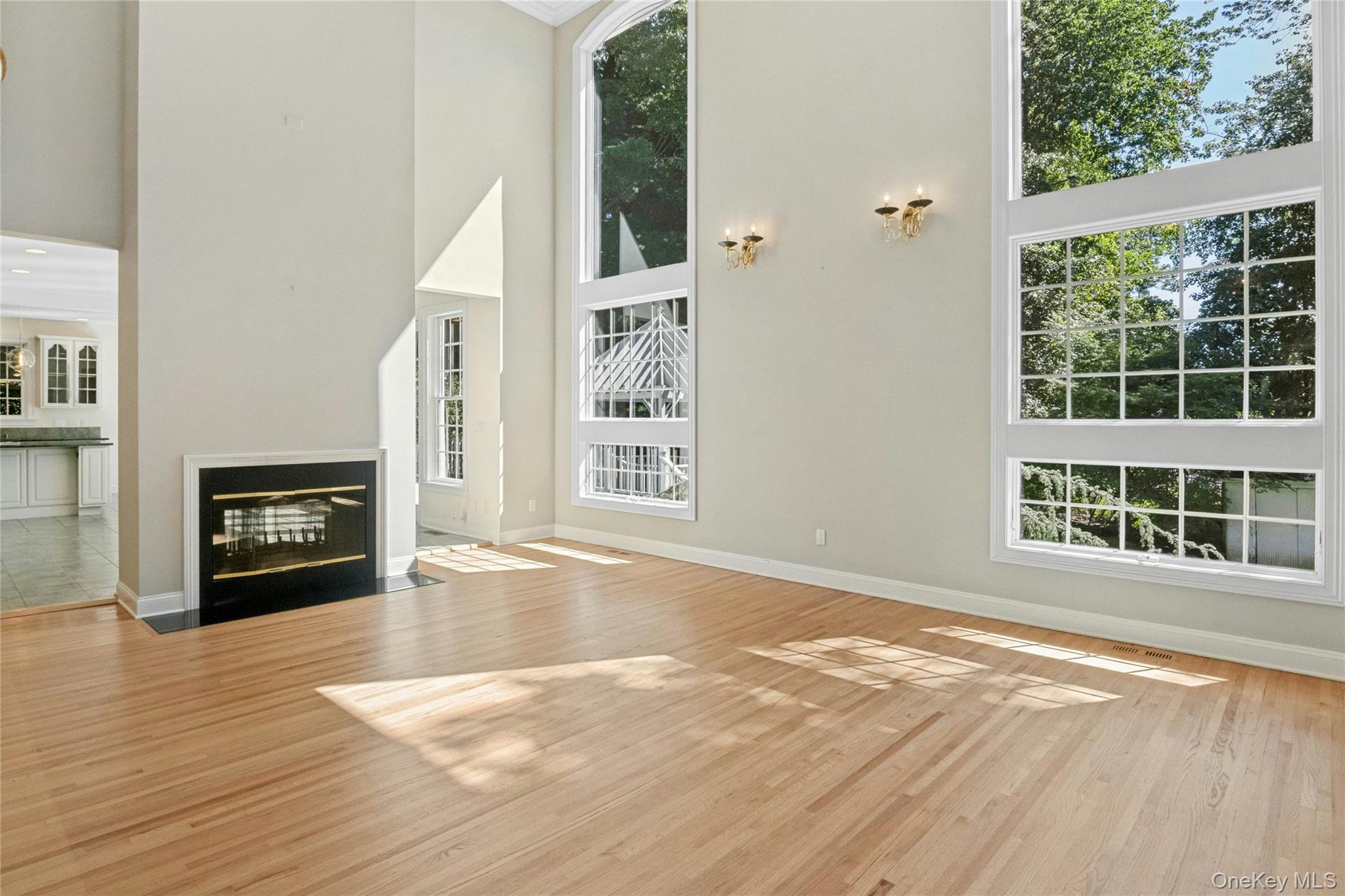 25 Riverview Road Irvington, NY 10533 - Photo 14 of 41 Living room with two story windows. An impressive room filled with natural light and views of the mature landscaping.