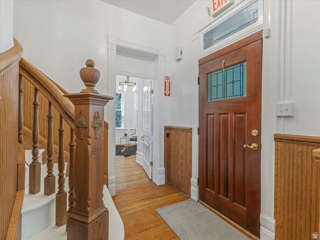 12825 South Fort Street Draper, UT 84020 - Photo 3 of 52 Hardwood flooring throughout the entryway, featuring an ornate wood staircase with a decorative newel post