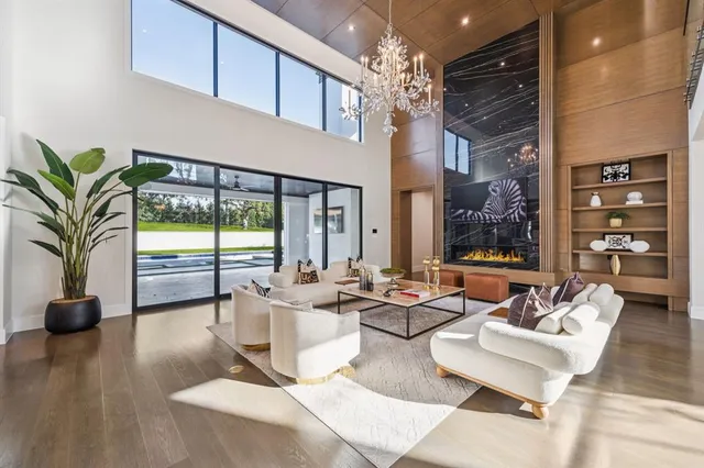 a living room with fireplace furniture and a large window