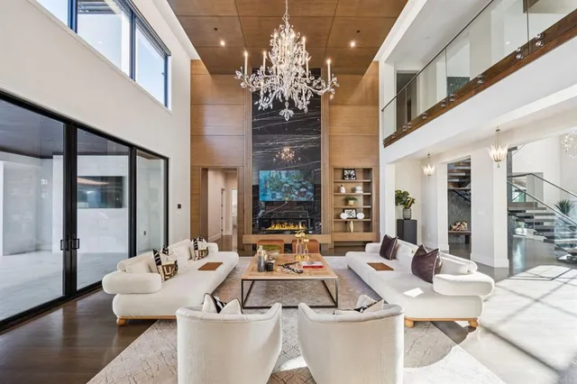 a living room with patio furniture and a chandelier