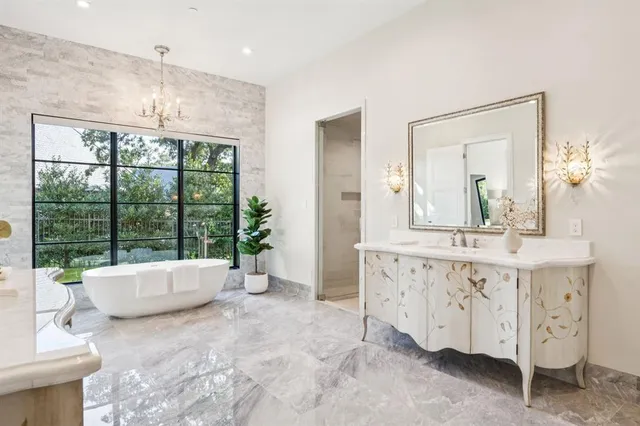 a spacious bathroom with a double vanity sink a mirror and a bathtub