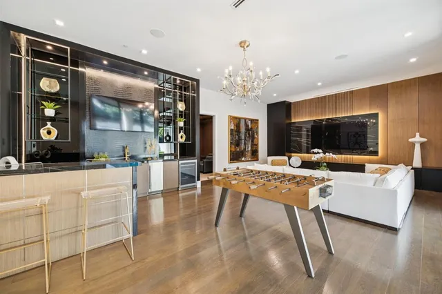 a living room with furniture a chandelier and a flat screen tv