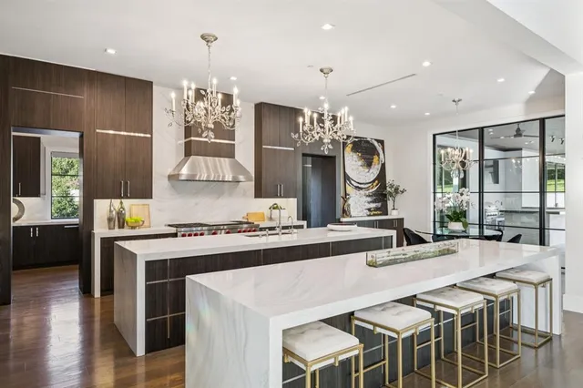 a kitchen with stainless steel appliances a dining table chairs and wooden floor