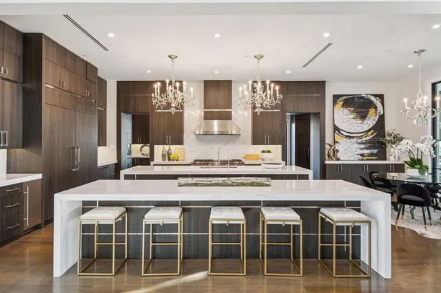 a large kitchen with stainless steel appliances kitchen island granite countertop a table and chairs in it