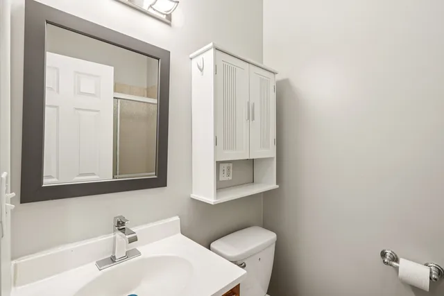 a bathroom with a sink a toilet and mirror