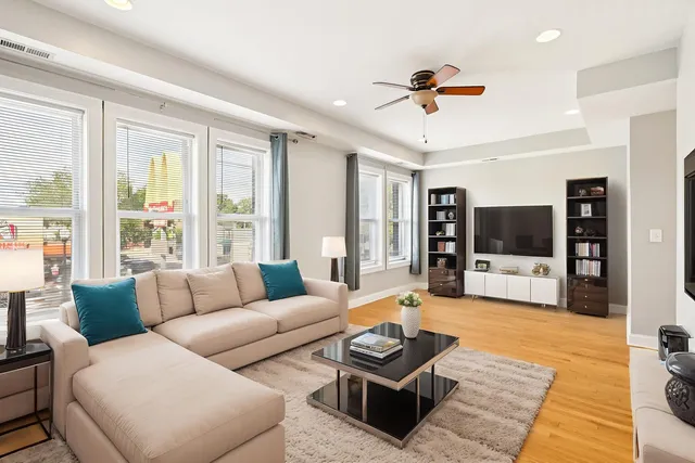 a living room with furniture a flat screen tv and a large window