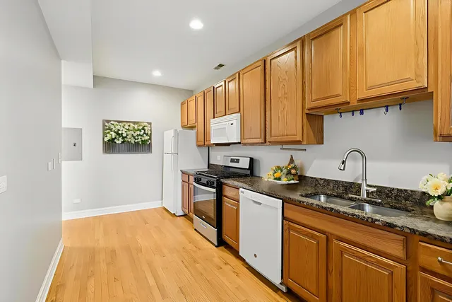 a kitchen with granite countertop a sink stainless steel appliances and cabinets