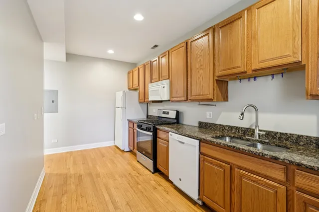 a kitchen with granite countertop a sink stainless steel appliances and cabinets