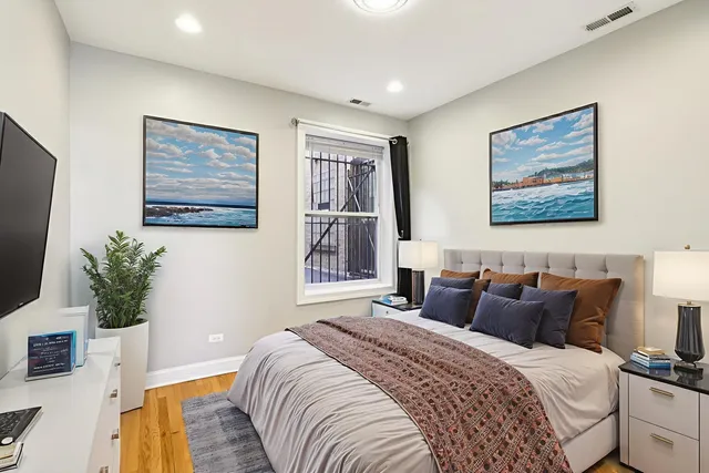 a bedroom with bed and paintings on the wall