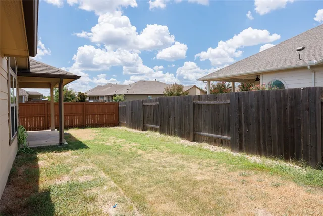 a backyard of a house with a table and chairs