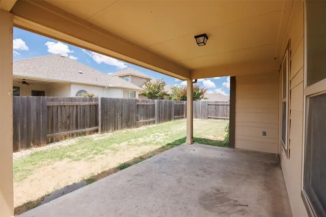 a view of backyard with wooden fence