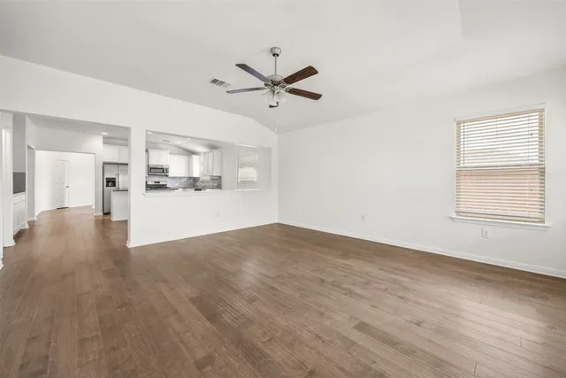 a view of a kitchen with wooden floor and a ceiling fan