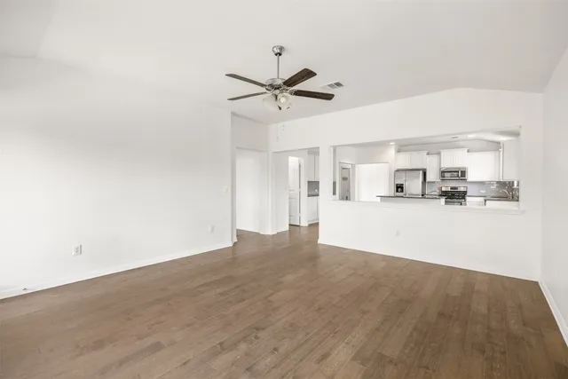 a view of a kitchen with cabinets and wooden floor
