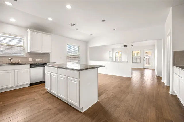 a kitchen with granite countertop white cabinets and white appliances