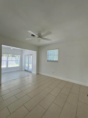 an empty room with windows and fan