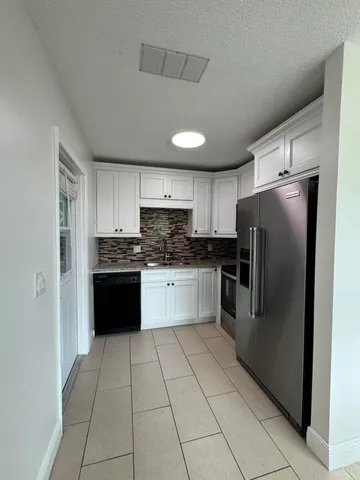 a kitchen with stainless steel appliances granite countertop a refrigerator and a stove top oven