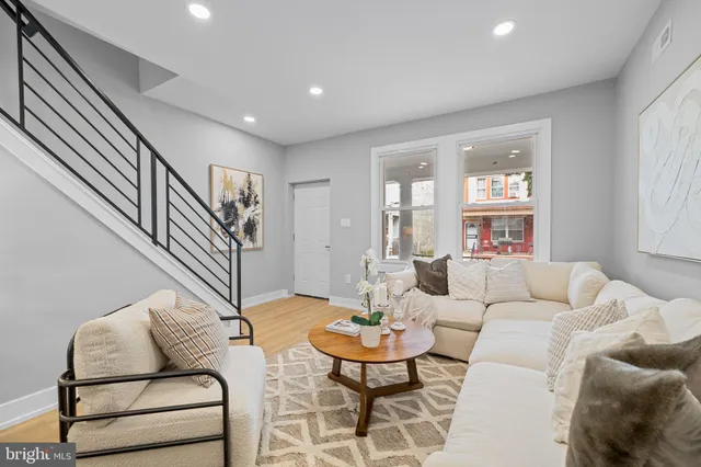 a living room with furniture and a wooden floor
