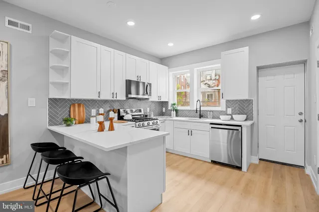 a kitchen with appliances a sink and cabinets