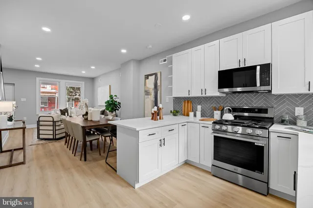 a kitchen with white cabinets and stainless steel appliances