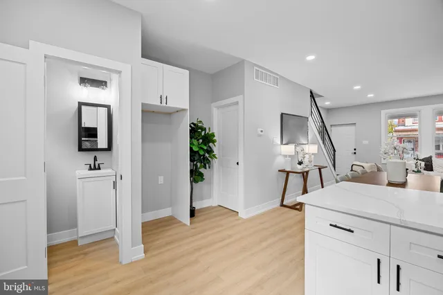 a view of a kitchen and an entryway with wooden floor