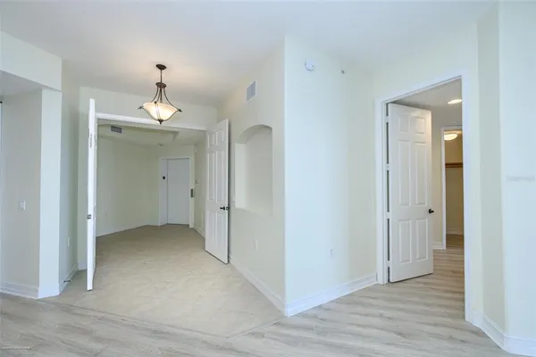an empty room with wooden floor and mirror