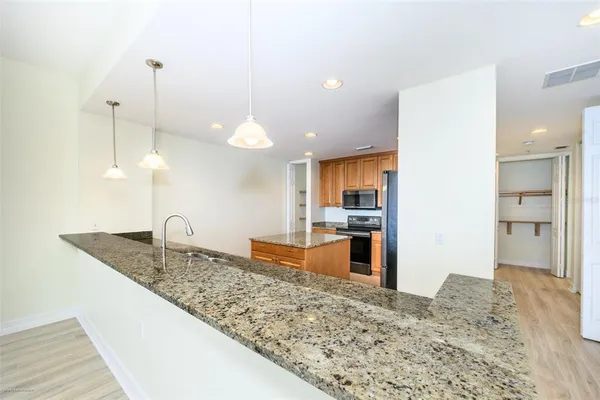 a kitchen with stainless steel appliances granite countertop a sink a oven and a refrigerator