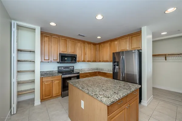 a kitchen with stainless steel appliances granite countertop a stove a refrigerator and a sink