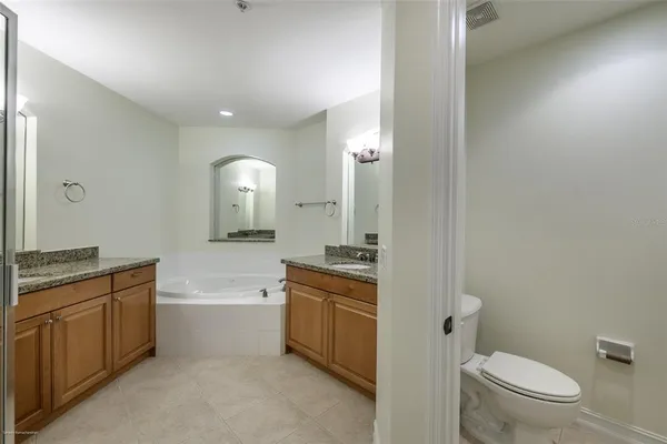 an empty room with wooden floor and a ceiling fan