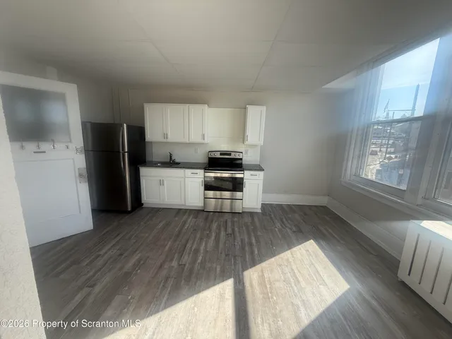 a kitchen with wooden floors and black appliances