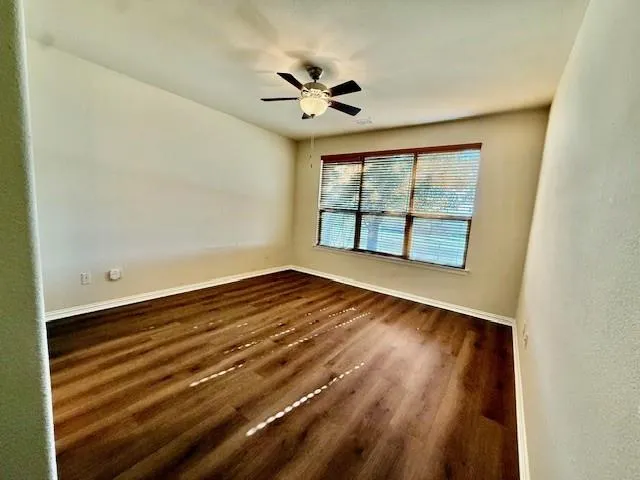 a view of empty room with wooden floor