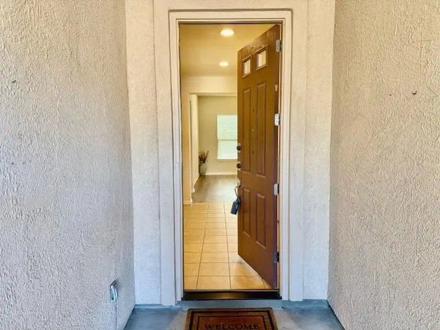 a view of a hallway with wooden floor and a bathroom