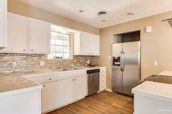 a kitchen with a sink cabinets stainless steel appliances and a window